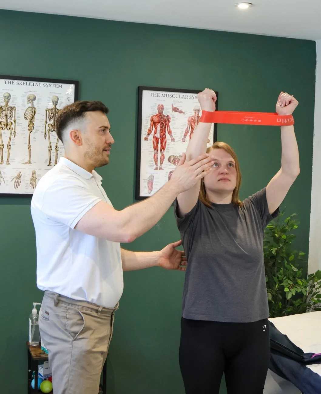 Josh Devine guiding a knee strengthening exercise with a resistance band